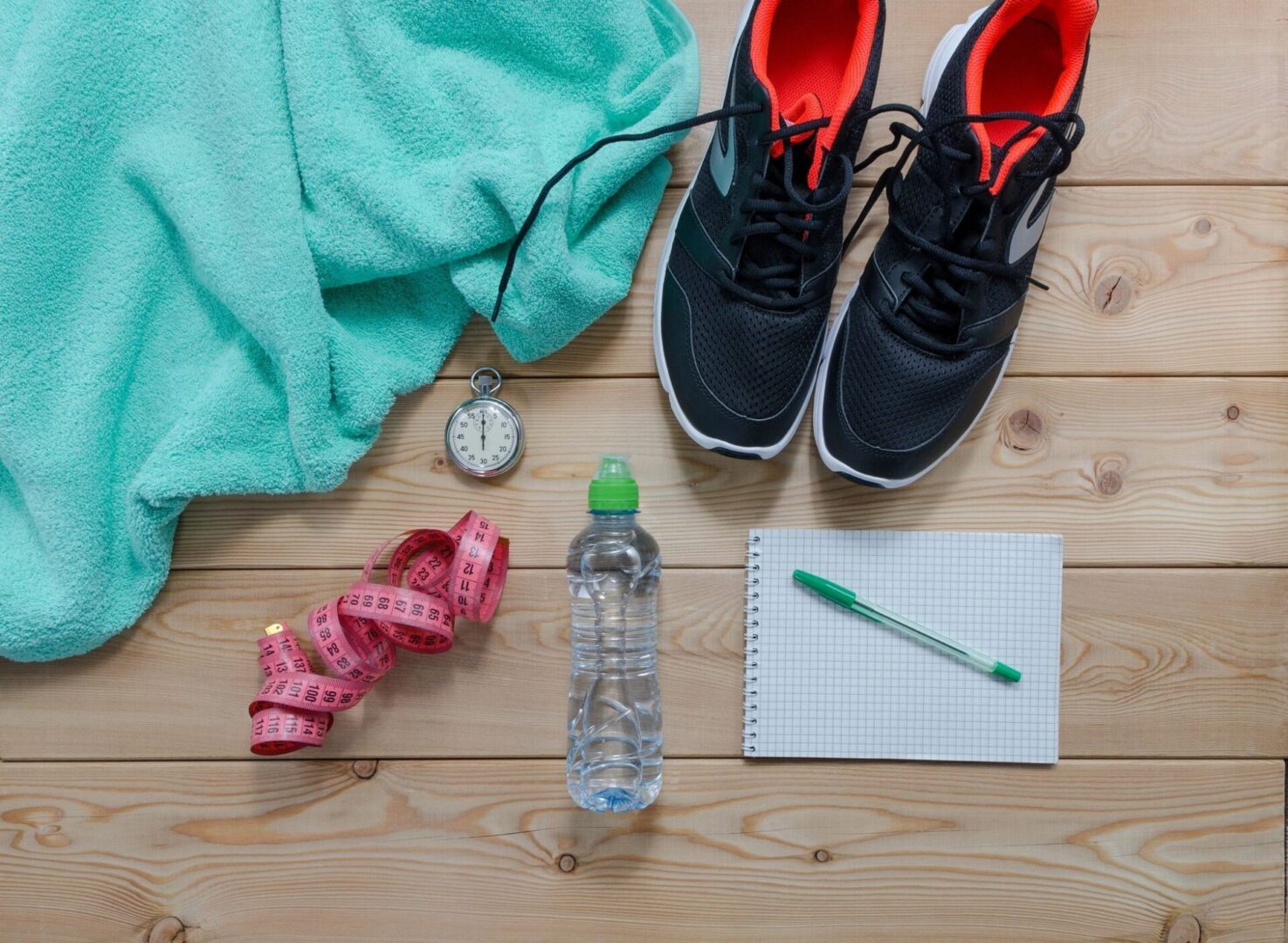 shoes, water bottle, note pad, a tape, clock. towel