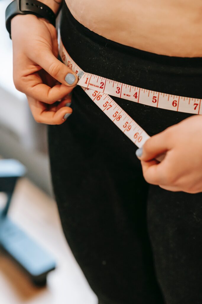 A person measuring their waist