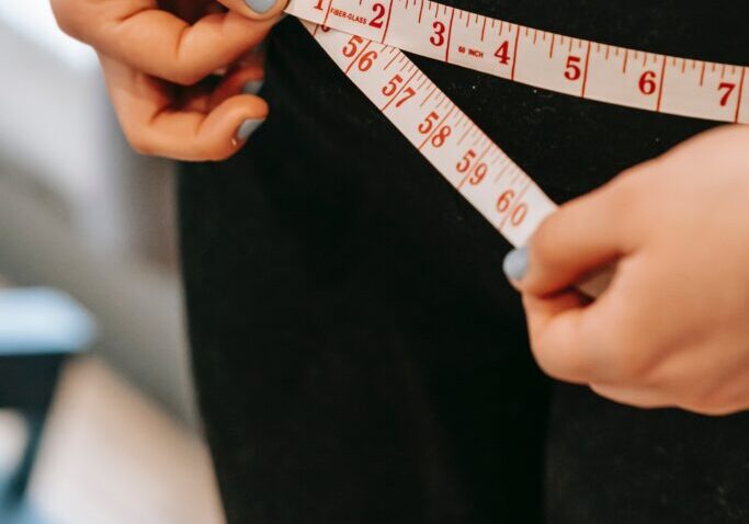 A person measuring their waist